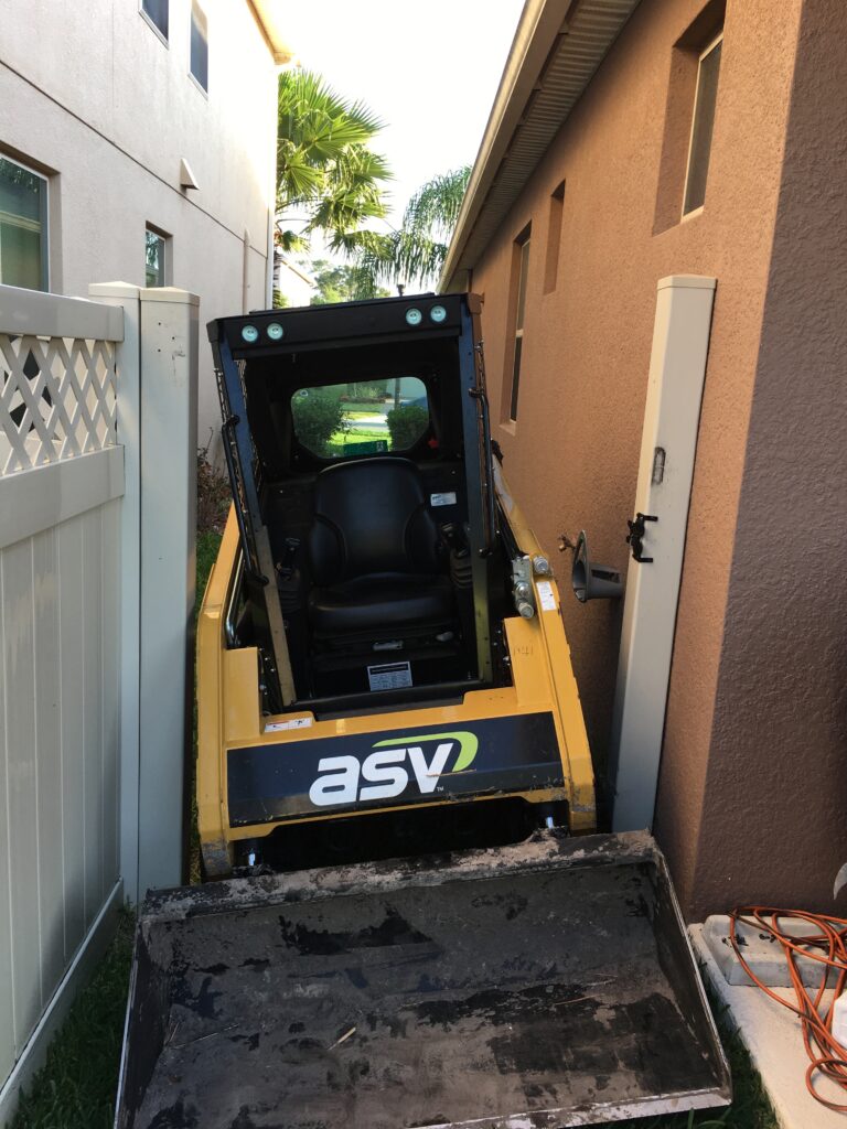 Skid/steer machine going through a vinyl gate opening in Orlando to excavate for an above ground pool